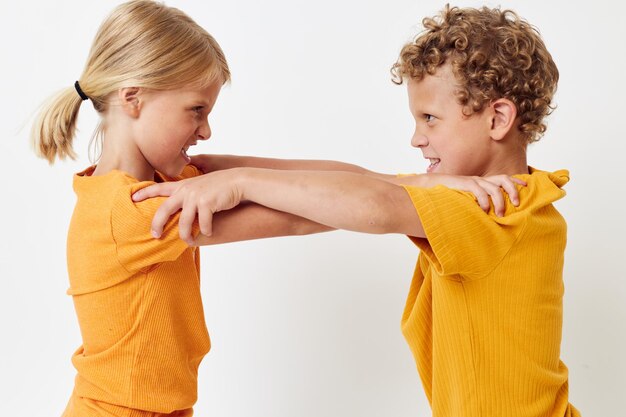 two joyful children yellow tshirts standing side by side childhood emotions light background unal 561613 1674